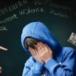 Adolescent victime de harcèlement scolaire et d'intimidation, illustrant la souffrance psychologique et l'isolement.